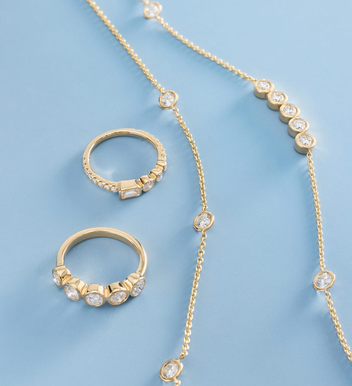 yellow gold bezel-set diamond ring and necklace displayed together